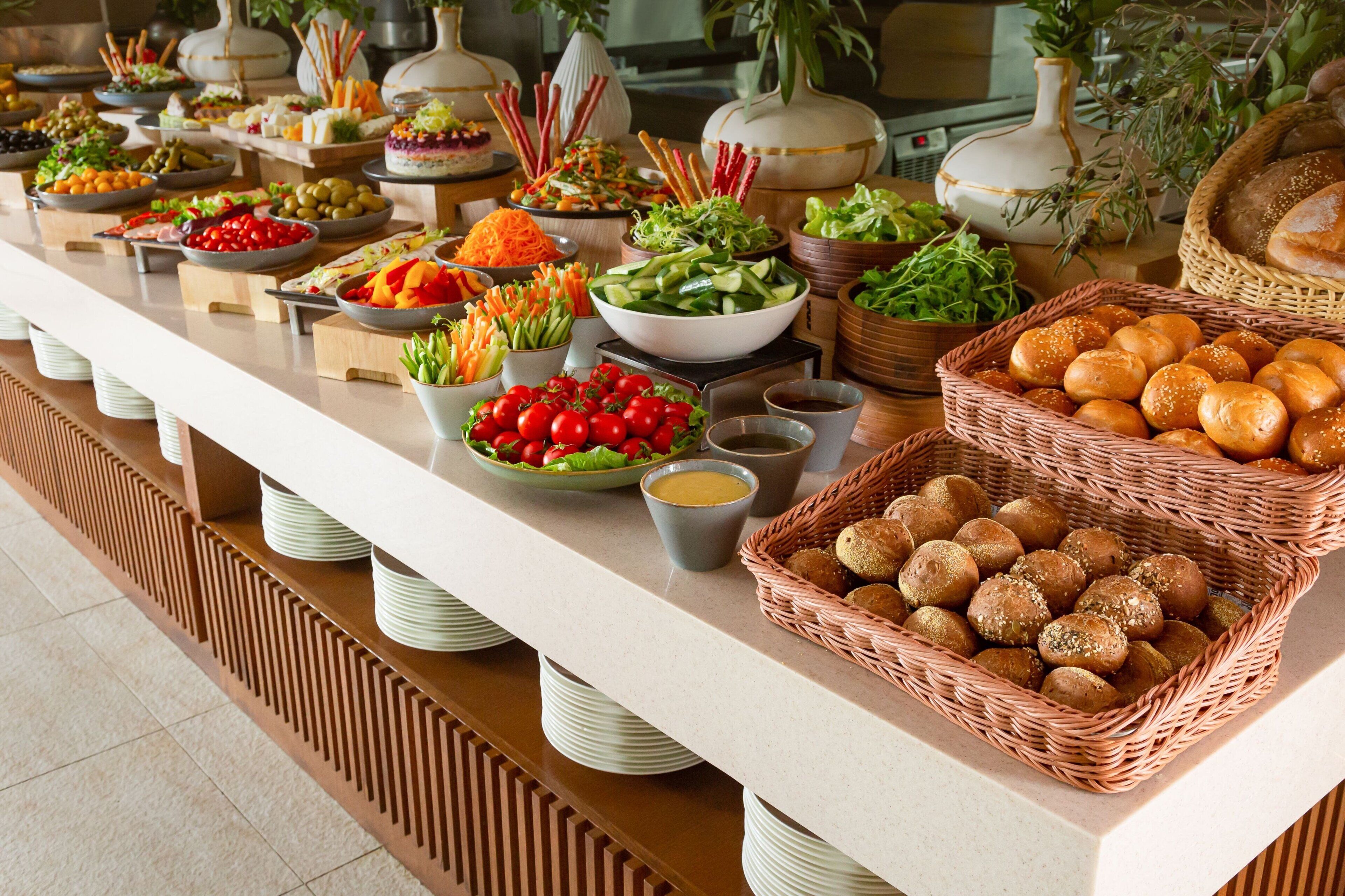 A buffet table with various food items and condiments.
