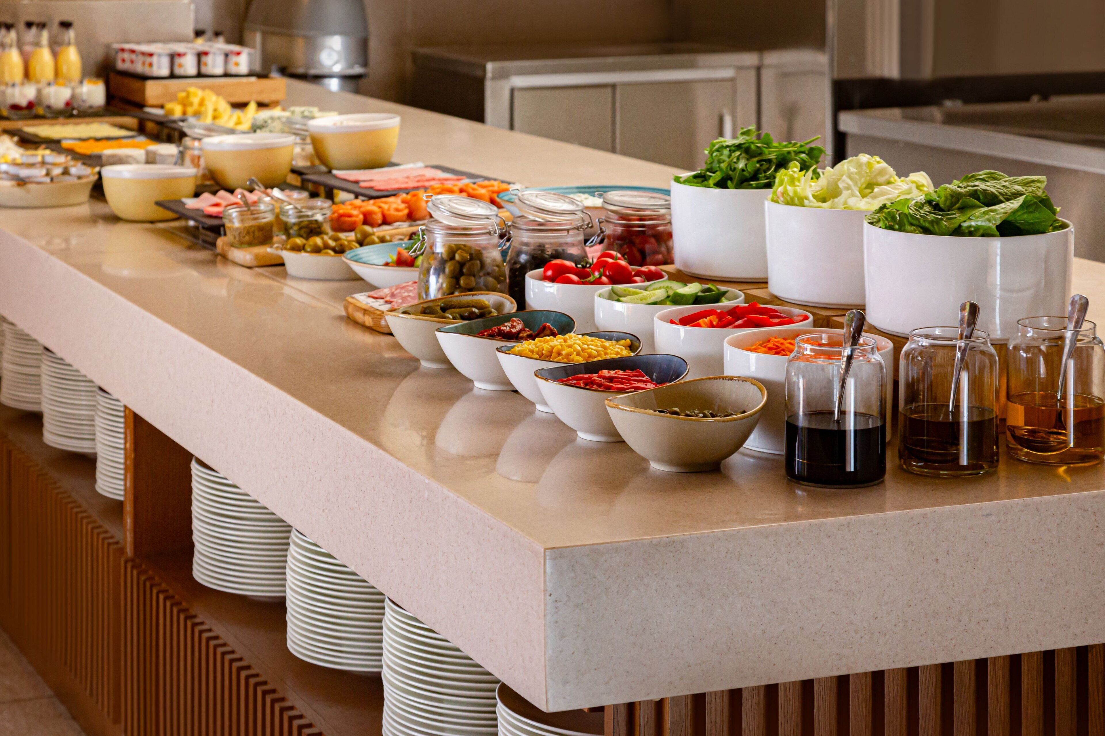 Una mesa de buffet con diversos alimentos y salsas.