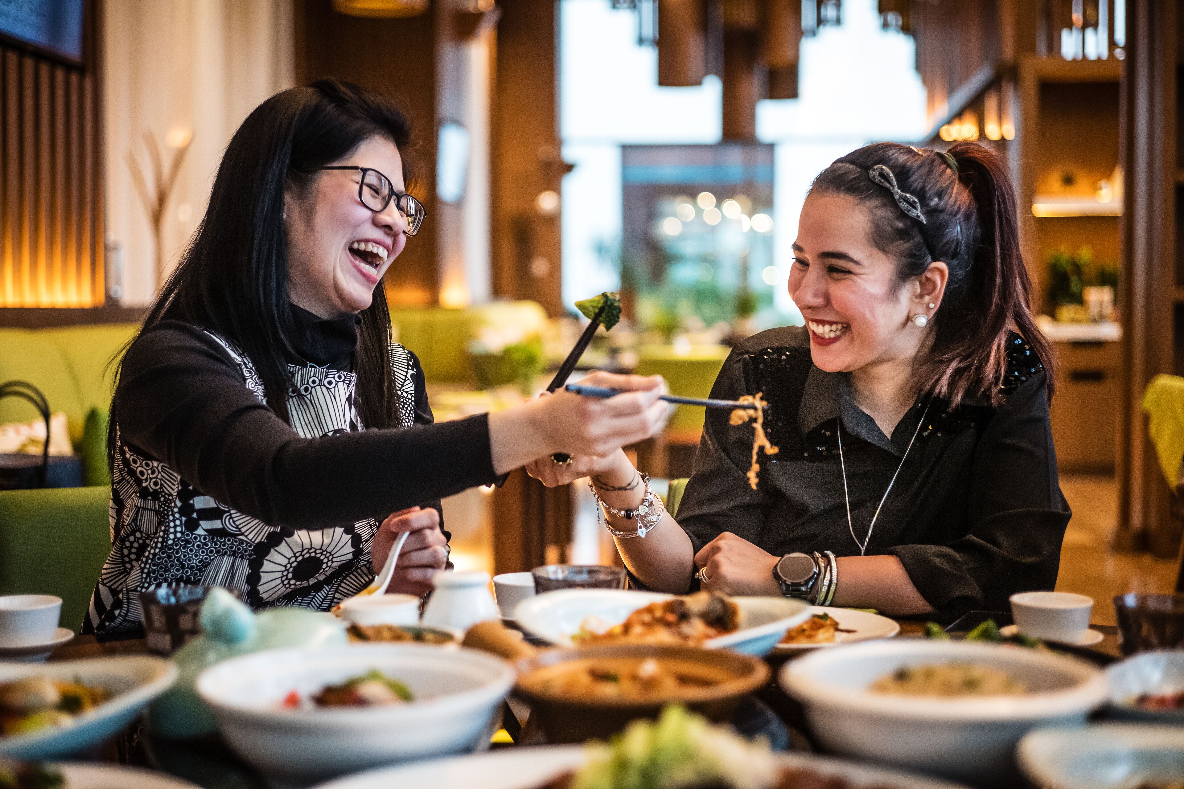 Two people dining at a restaurant with various dishes on the table.