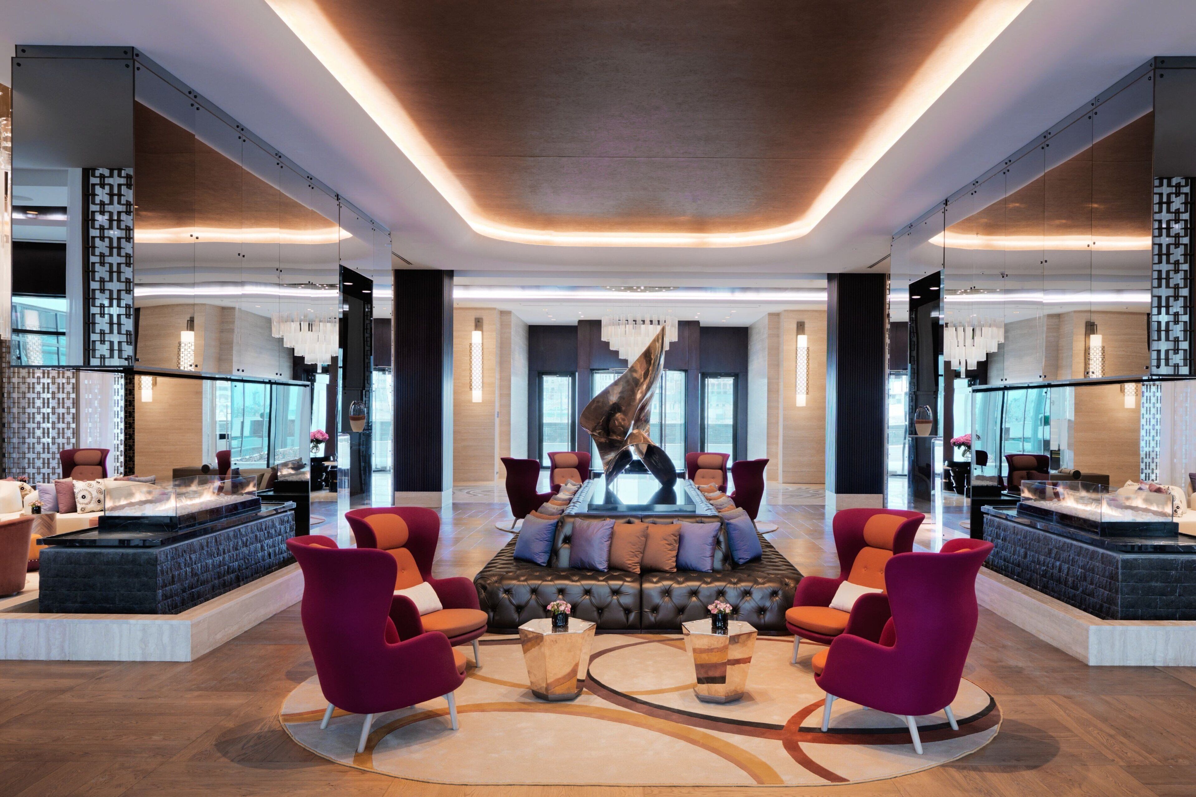 A spacious lobby with a central seating area, a fire feature, and modern decor.