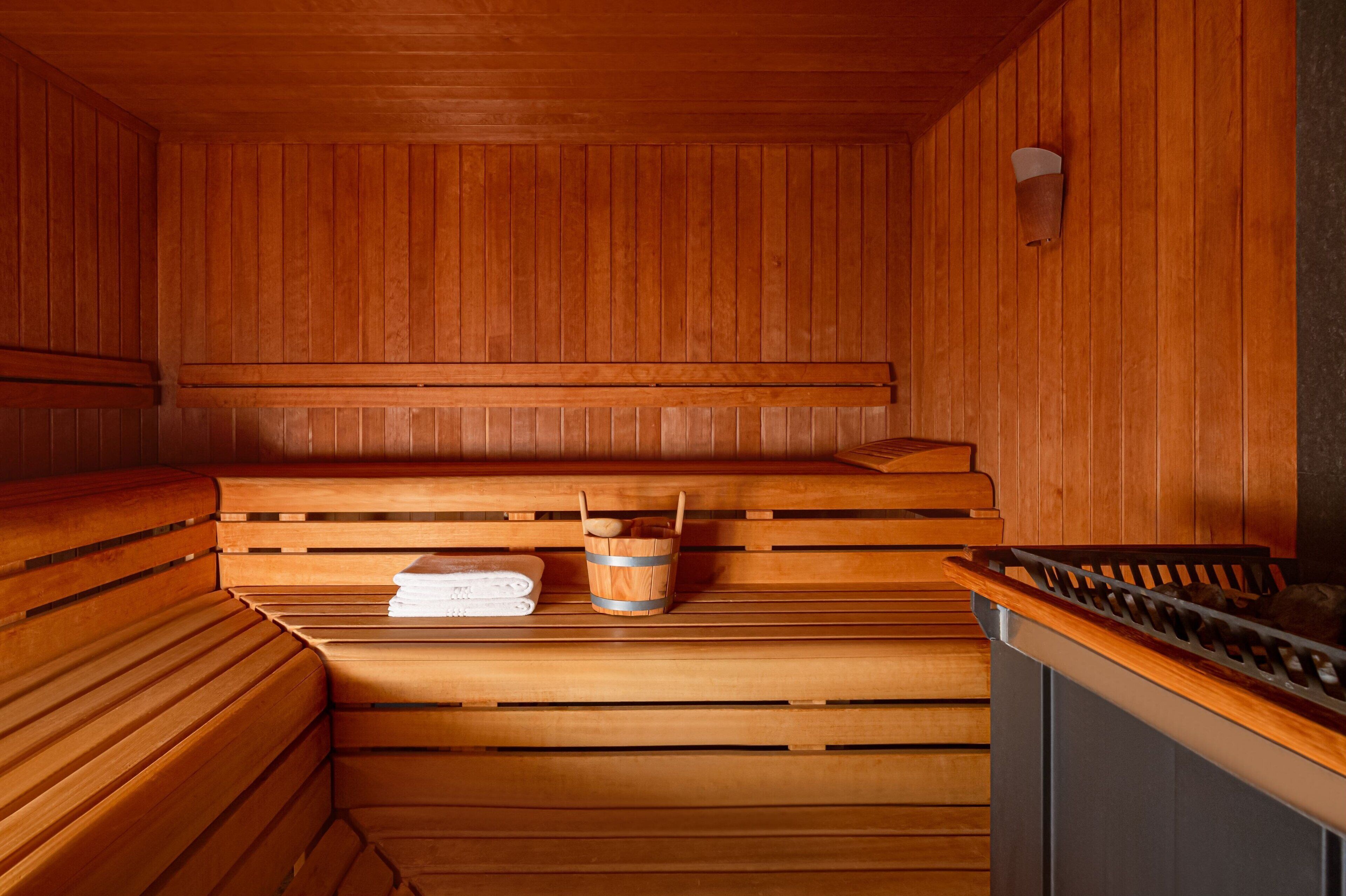 A sauna with wooden benches and a wooden wall.