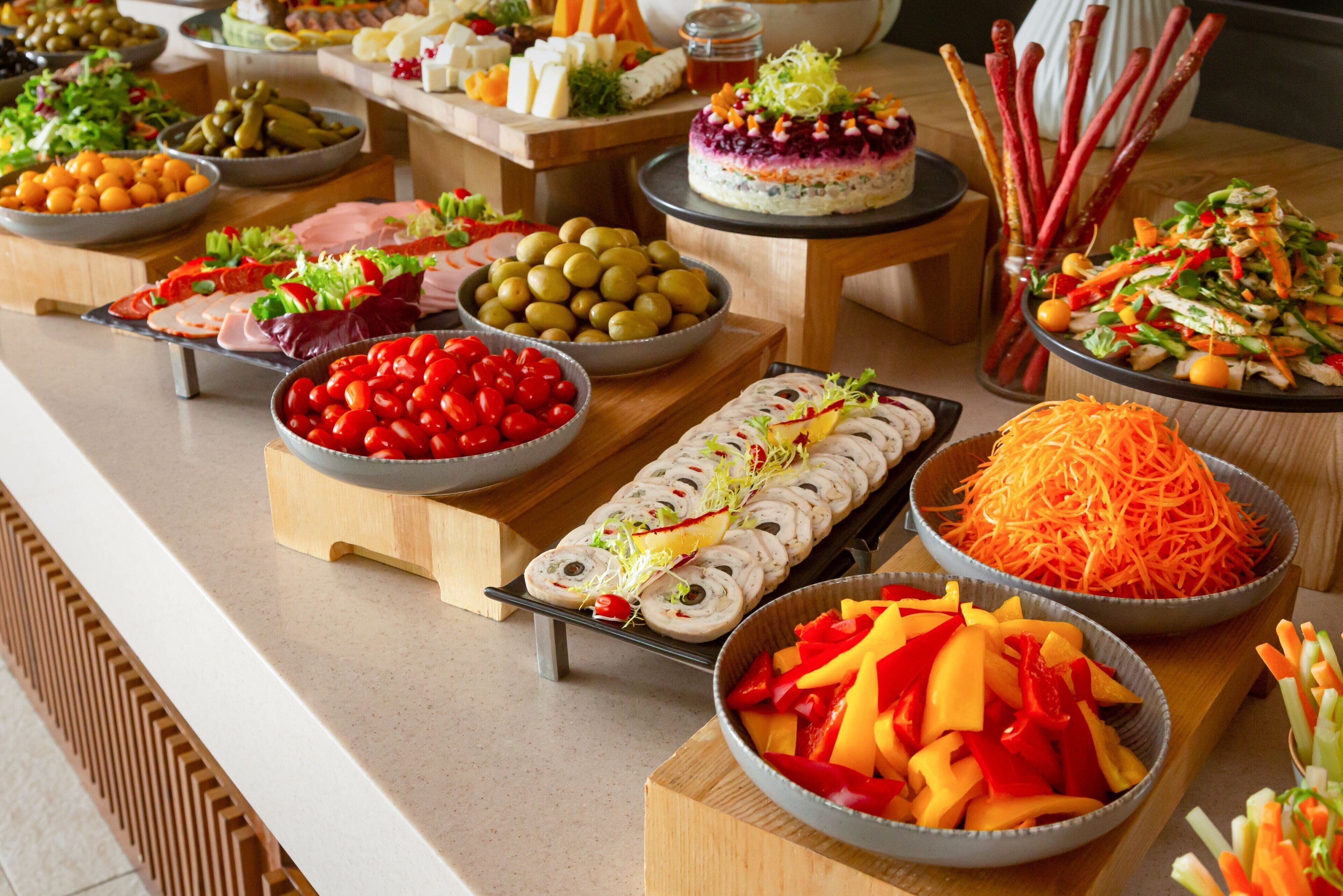 Un buffet proposant une variété de plats, notamment des salades, des viandes et des légumes.