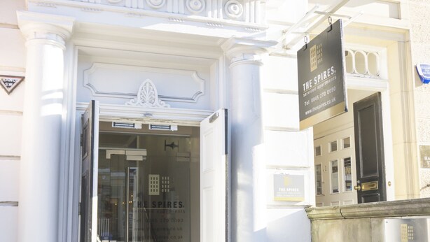 A building entrance with a glass door, a sign for 'The Spires' apartments, and a small step leading up to the door. - The Spires Serviced Apartments Edinburgh (Edinburgh)