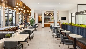 A modern restaurant with high ceilings, pendant lighting, and a mix of seating options including tables and booths. - Element by Marriott Bozeman (Bozeman)