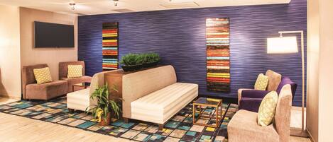 A modern living room with a sofa, armchairs, a coffee table, and a patterned rug.