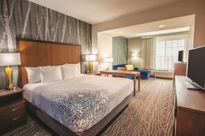 A hotel room with a large bed, a desk, a chair, and a television. - La Quinta Inn & Suites by Wyndham Duluth (Duluth)