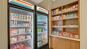 Un vitrina refrigerada amb diversos aliments i una prestatgeria plena d'aperitius.