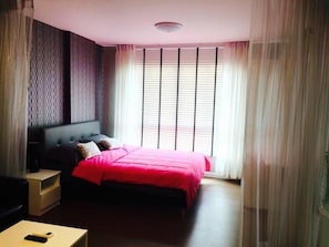 Une chambre à coucher comprenant un lit, des tables de chevet, une commode, un bureau et une chaise.