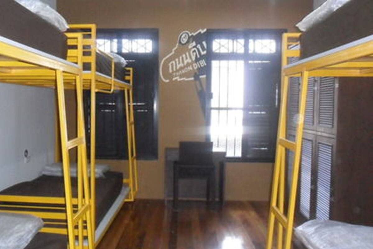 Un dormitorio con literas y una ventana con persianas.