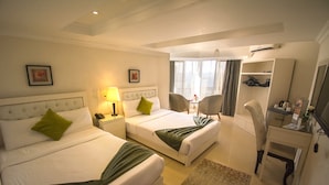 A hotel room with two beds, a desk, a chair, a wardrobe, and a bathroom. - Nile Boutique hotel (Giza)