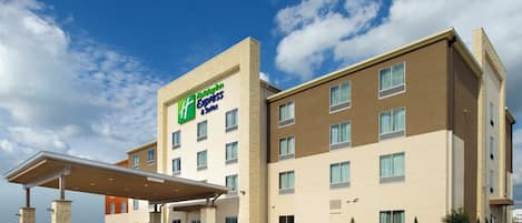 Un hôtel Holiday Inn Express au design moderne, doté d’une entrée abritée et offrant une vue dégagée sur le ciel.