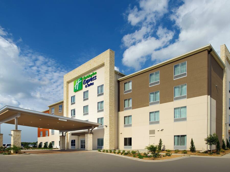 Un hôtel Holiday Inn Express au design moderne, doté d’une entrée abritée et offrant une vue dégagée sur le ciel.