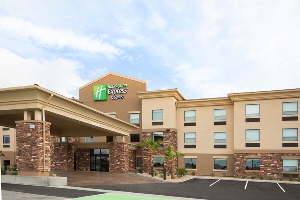 A Holiday Inn Express & Suites building with a brick facade, multiple windows, and a parking lot. - Holiday Inn Express & Suites Pahrump by IHG (Pahrump)