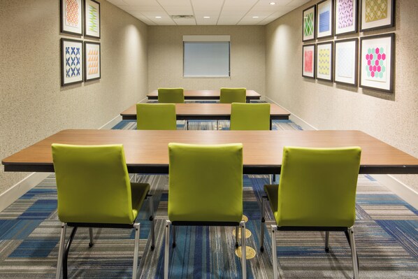 A conference room with a long table, six chairs, and framed artwork on the walls. - Holiday Inn Express & Suites Pahrump by IHG (Pahrump)