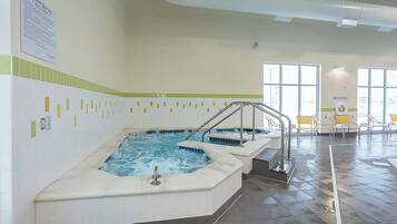 A spa area with two hot tubs, a tiled floor, and a 'NO DIVING' sign.