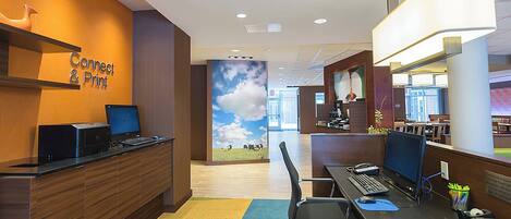 A modern office space with a reception desk, computers, and a colorful carpet.