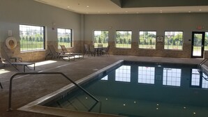 Une piscine avec des chaises longues et une vue sur la verdure environnante.