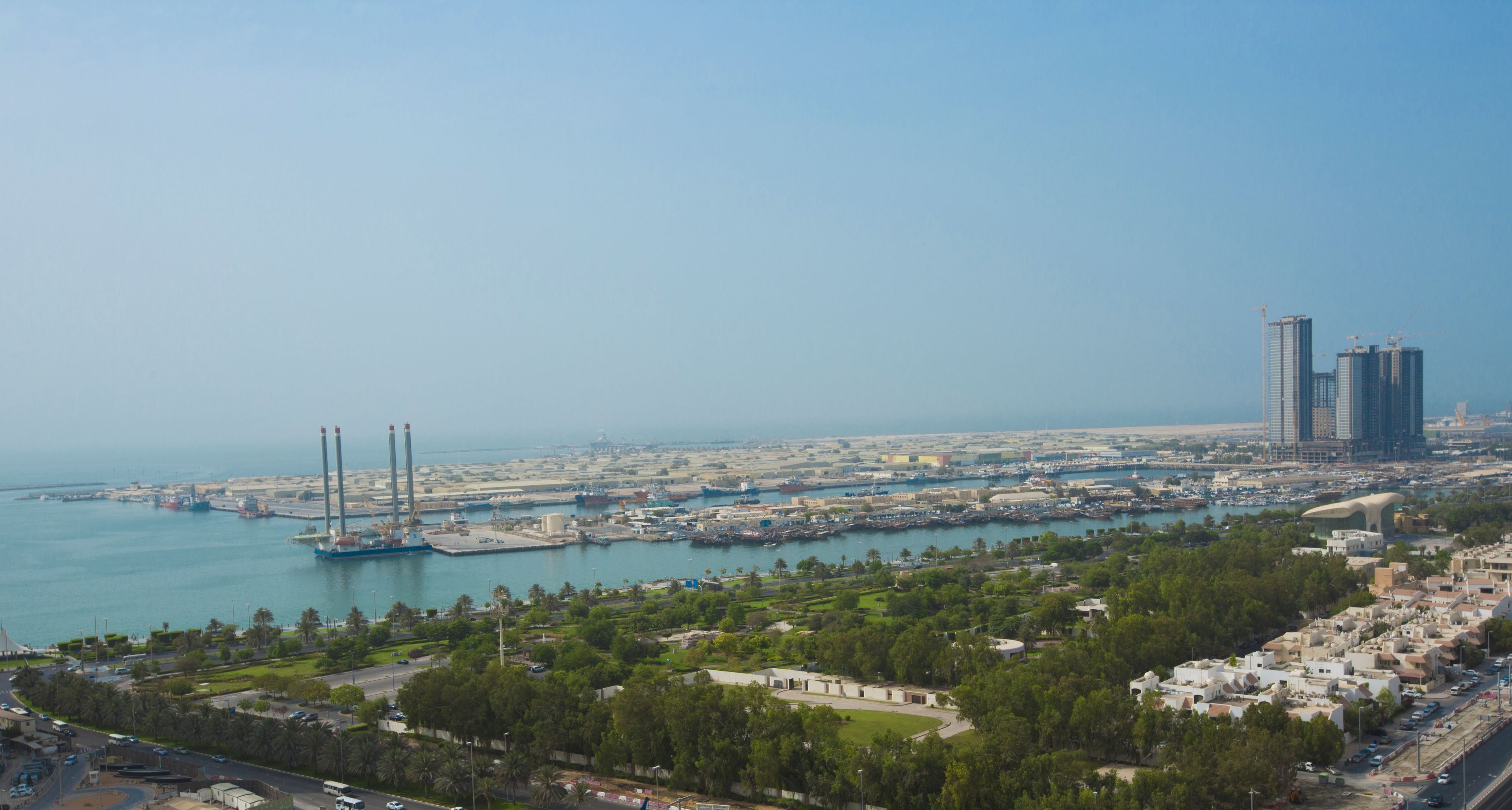 A coastal cityscape with a marina, high-rise buildings, and a mix of residential and commercial areas.
