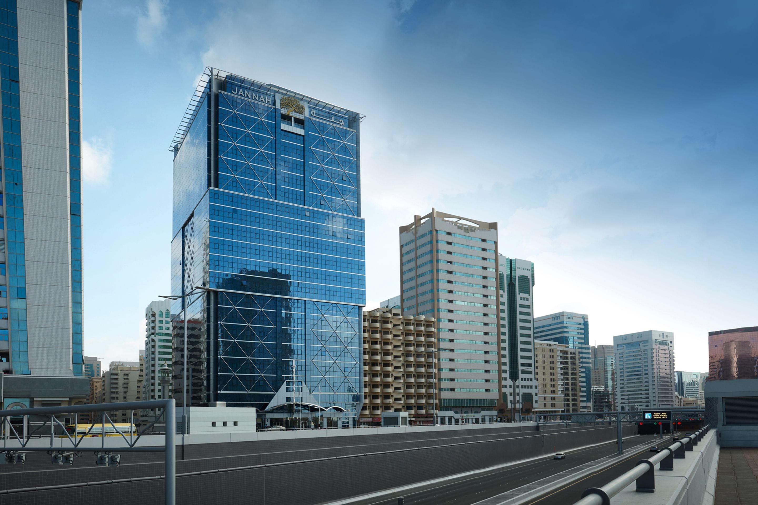 Paisatge urbà modern amb edificis alts, incloent un edifici de vidre blau destacat.