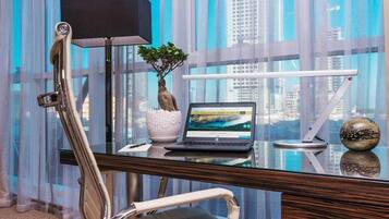 A modern office desk with a laptop, a potted plant, and a decorative sphere.