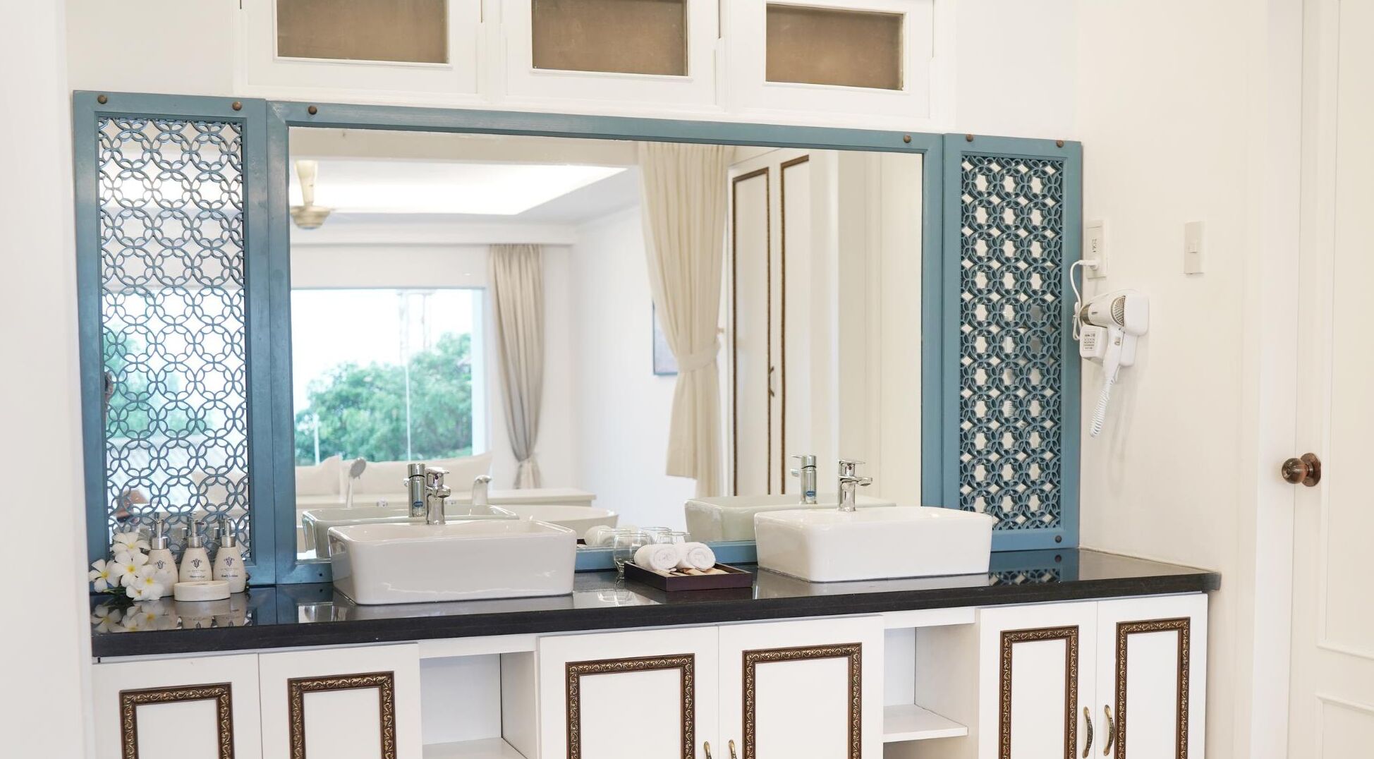 A bathroom with two sinks, a large mirror, and a shower area.