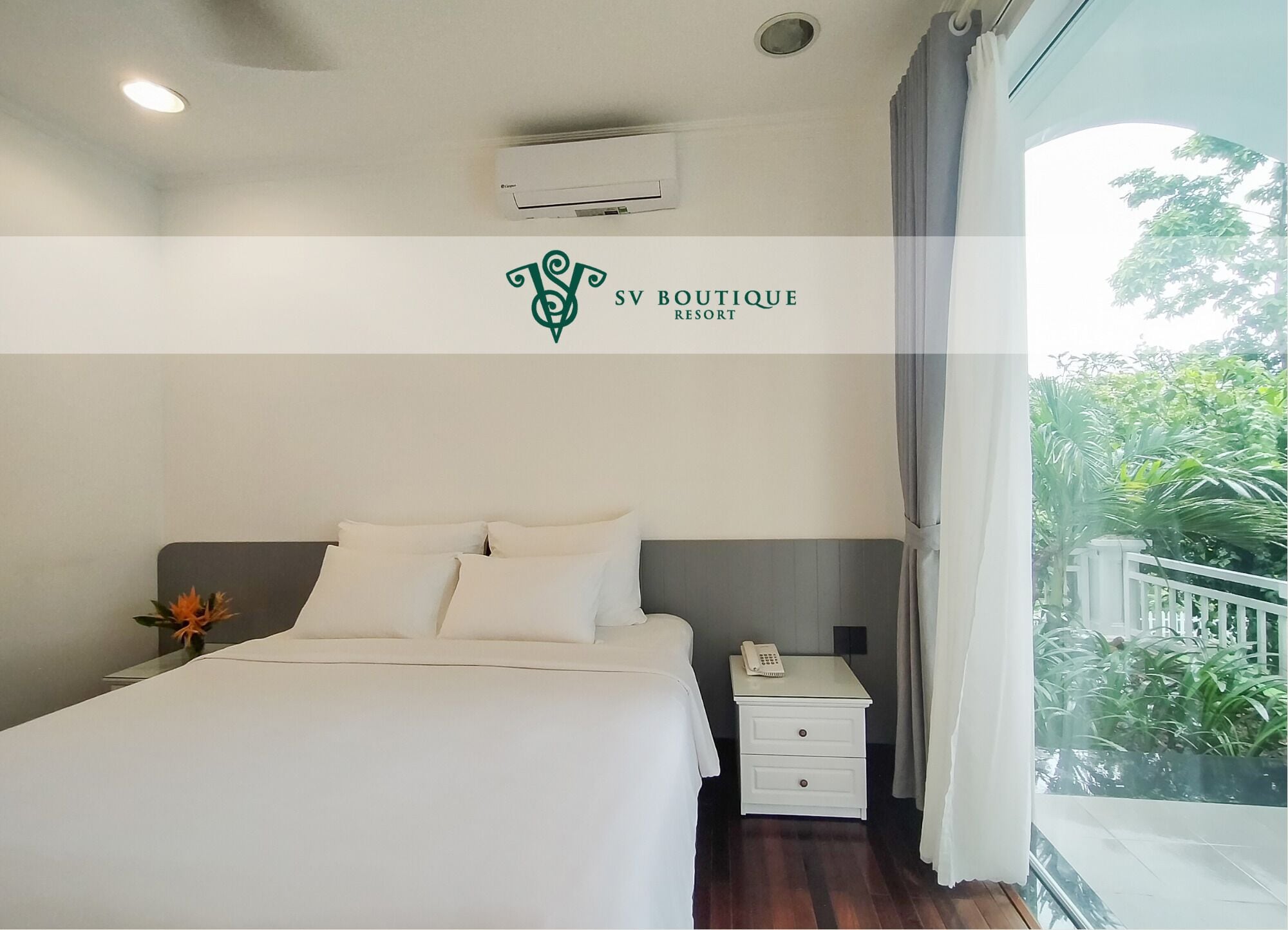 A hotel room with a bed, bedside table, and an air conditioning unit.