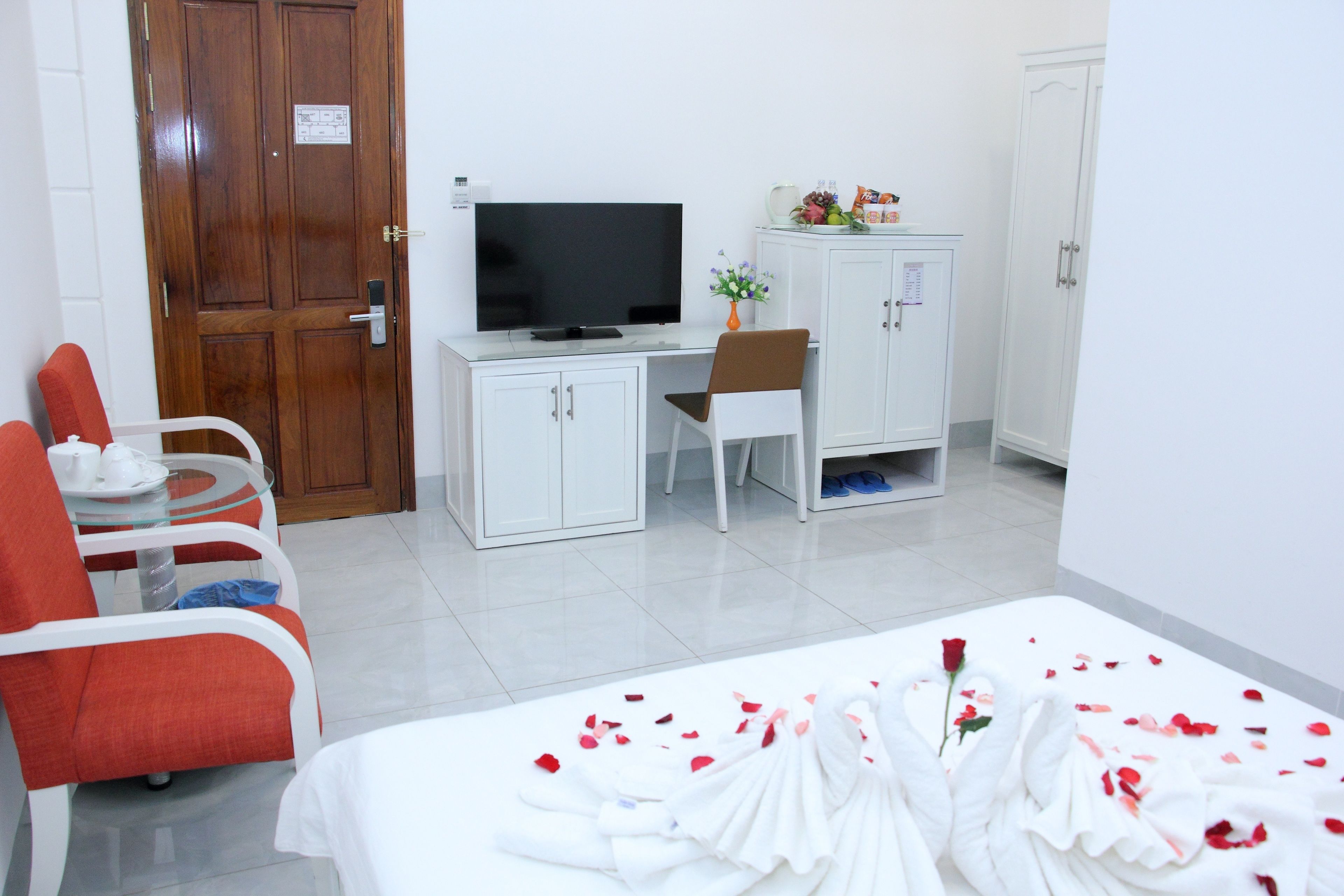 Une chambre d’hôtel équipée d’un lit, d’une télévision, d’un bureau, d’une chaise et d’une armoire.