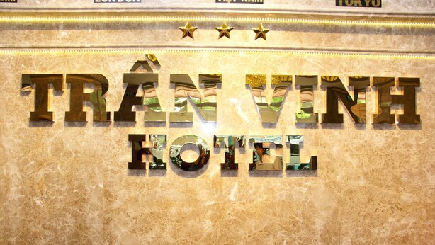 Señal del hotel Trần Vinh, con fondo de mármol y decoraciones de estrellas.