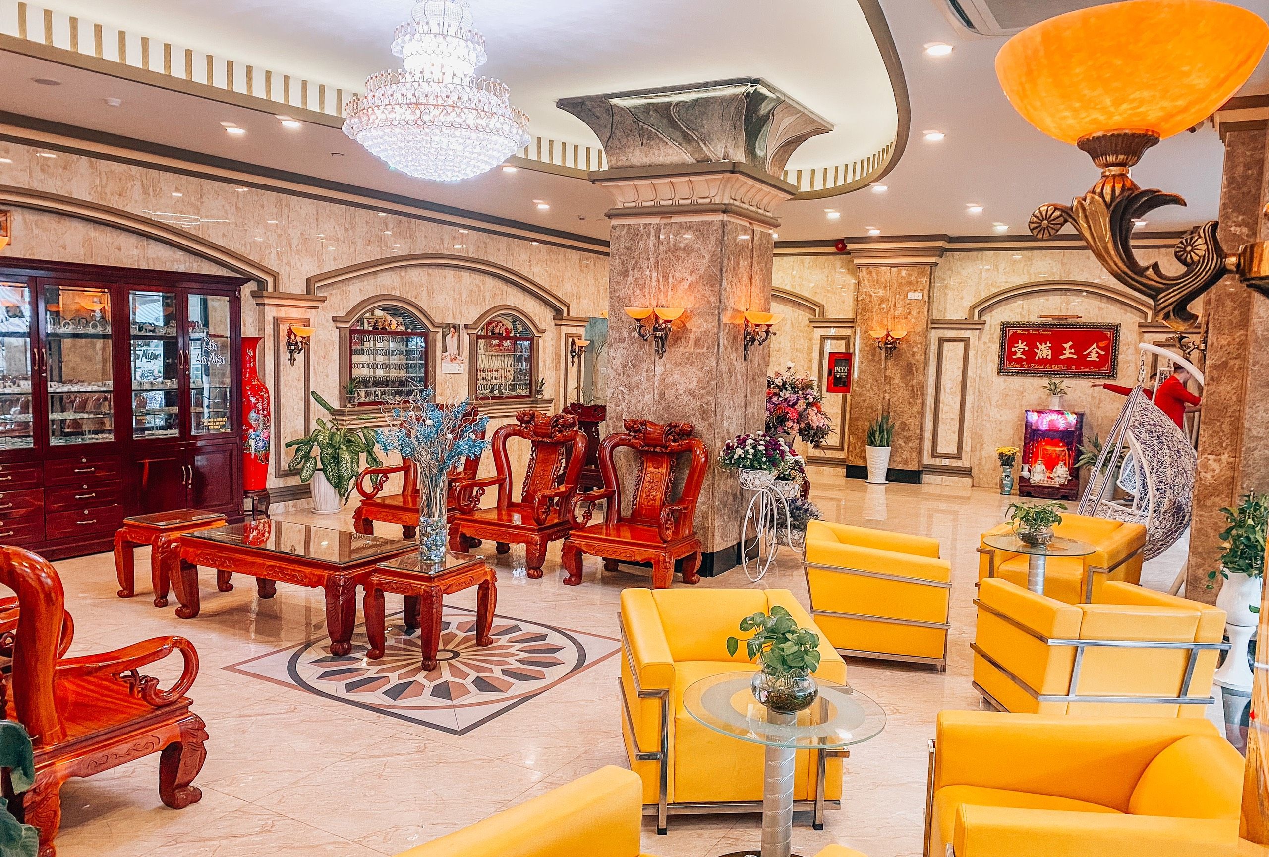 A lobby with ornate furniture, a chandelier, and a traditional Chinese decorative element.