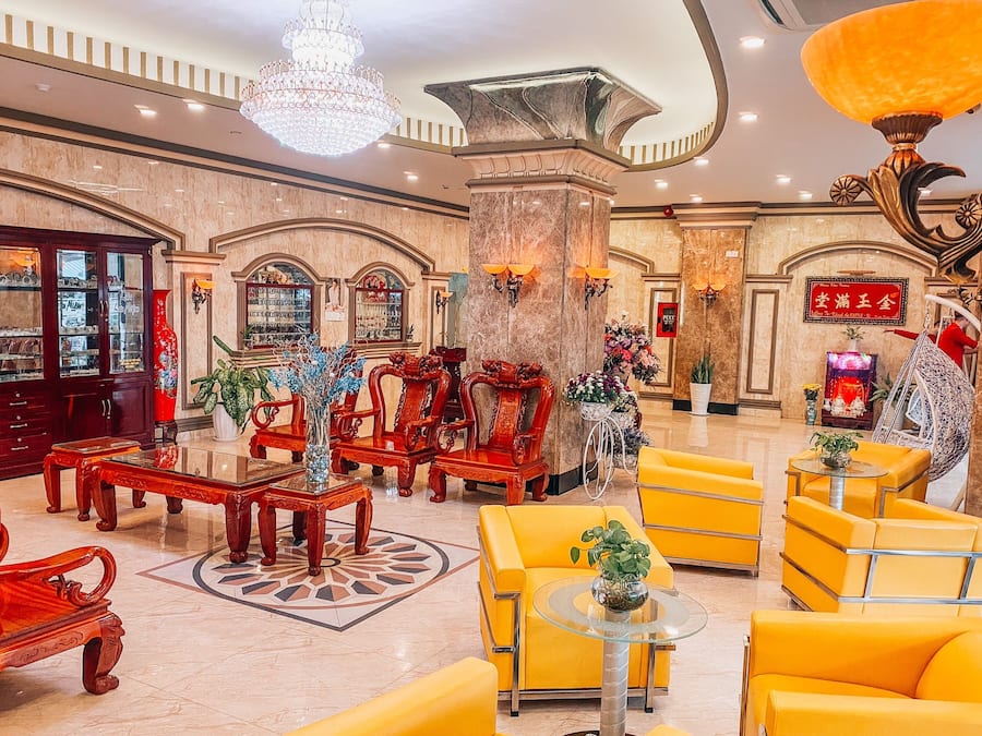 A lobby with ornate furniture, a chandelier, and a traditional Chinese decorative element.