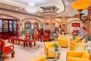 Un hall con muebles ornamentados, una araña y un detalle decorativo tradicional chino.