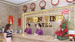Un mostrador de recepción de hotel con relojes que muestran la hora en Nueva York, Londres, Tokio y Sídney.