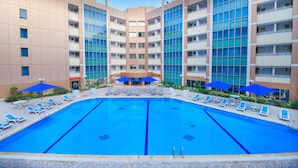 A swimming pool with lounge chairs and umbrellas, surrounded by multi-story buildings with balconies. - Tolip El Galaa Cairo Hotel (Cairo)