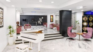 A modern living room with a grand piano, plush seating, and a decorative wall. - Tolip El Galaa Cairo Hotel (Cairo)