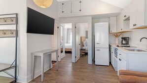A modern kitchen with white cabinets, a built-in oven, and a coffee machine. - Ocean Surf at York Beach (York Beach)