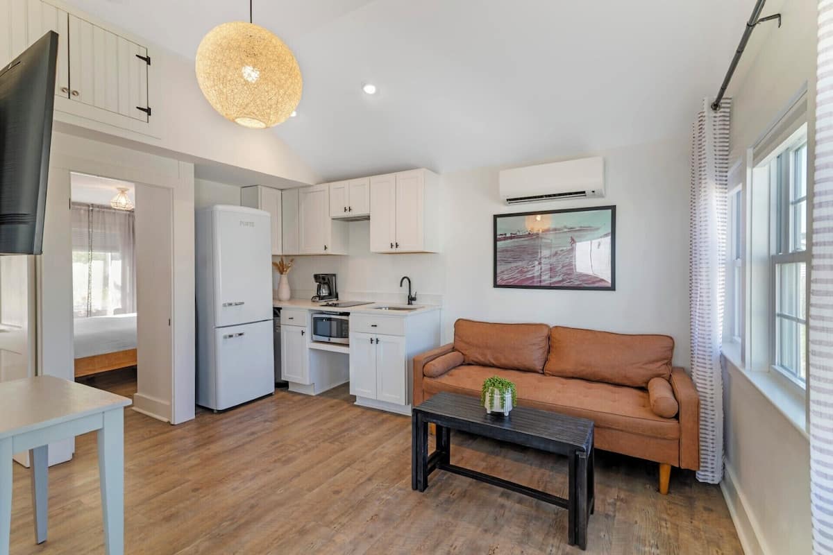 A compact kitchen with white cabinets, a built-in oven, and a coffee maker.