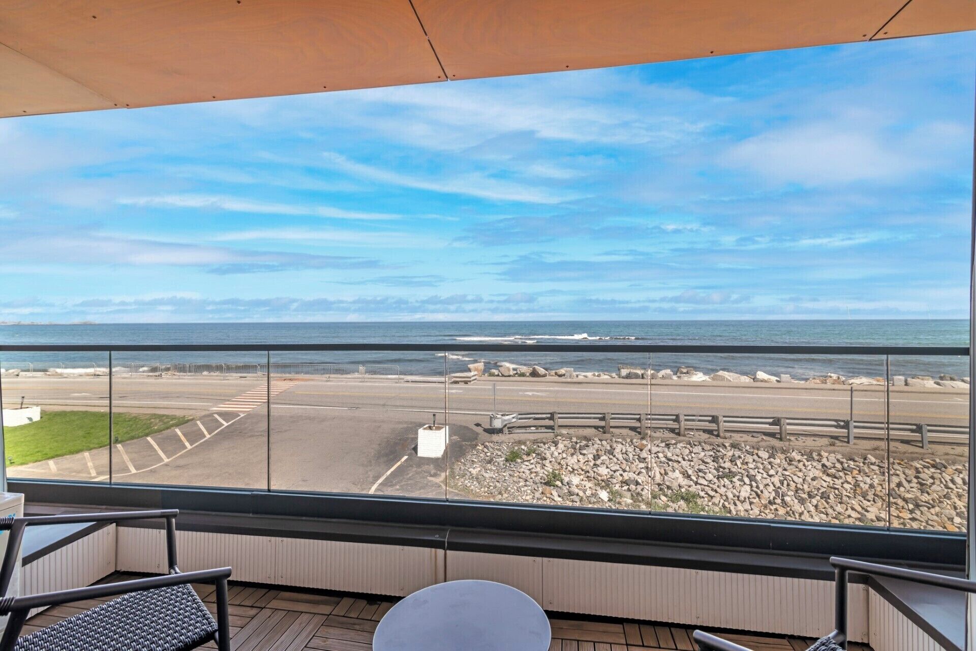 A balcony with a view of the beach and ocean.
