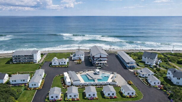 A coastal residential area with houses, a swimming pool, and the ocean in the background. - Ocean Surf at York Beach (York Beach)