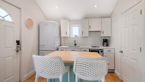 A compact kitchen with white cabinets, a built-in oven, and a coffee maker. - Ocean Surf at York Beach (York Beach)