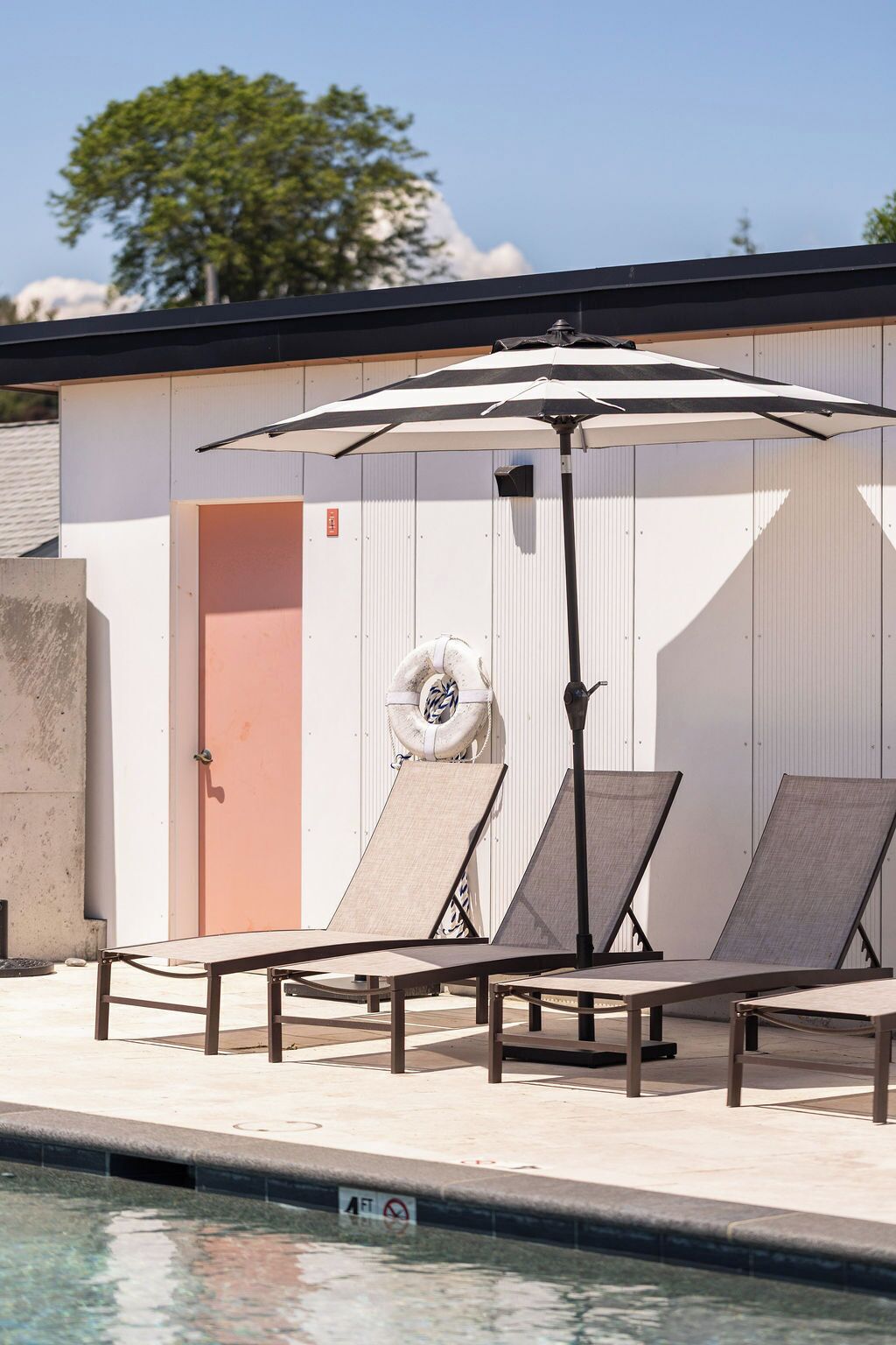 A poolside area with lounge chairs and a canopy umbrella.