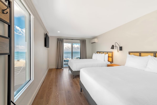 A hotel room with two beds, a TV, a window with a view of the sea, and a balcony. - Ocean Surf at York Beach (York Beach)