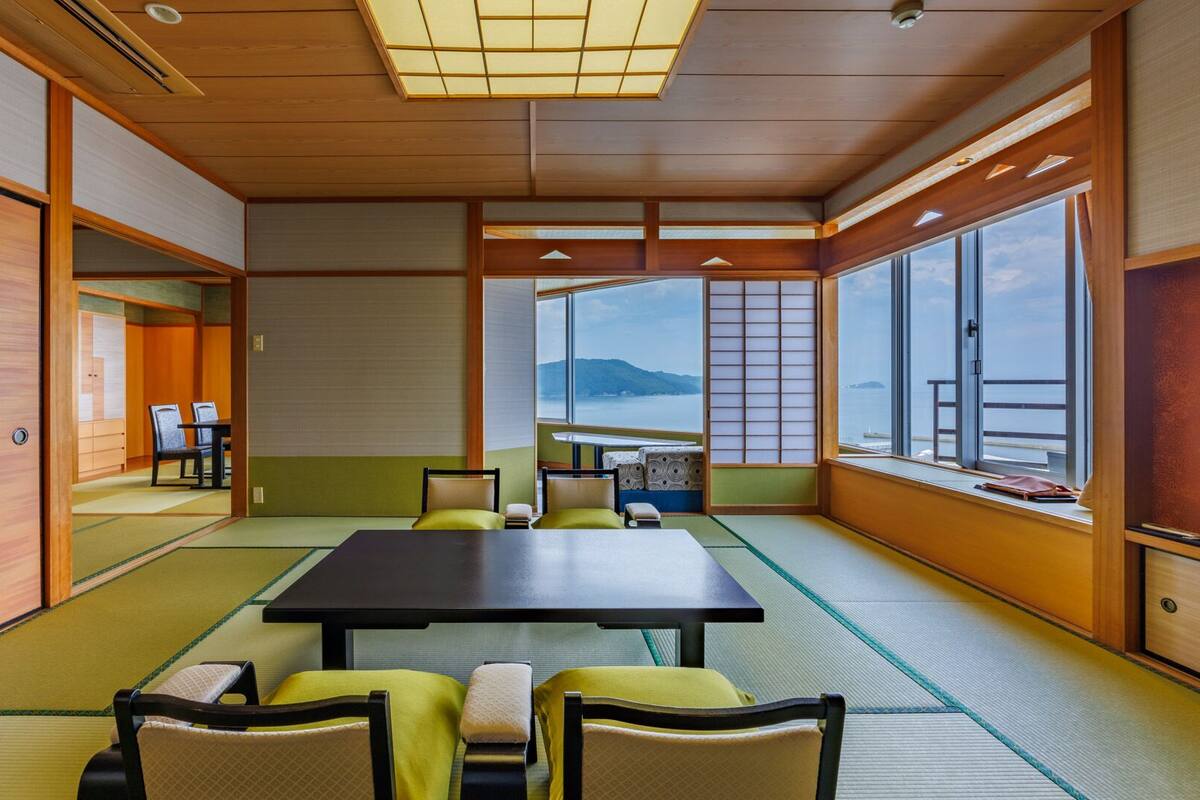 A traditional Japanese-style room with tatami flooring, a low table, and chairs.