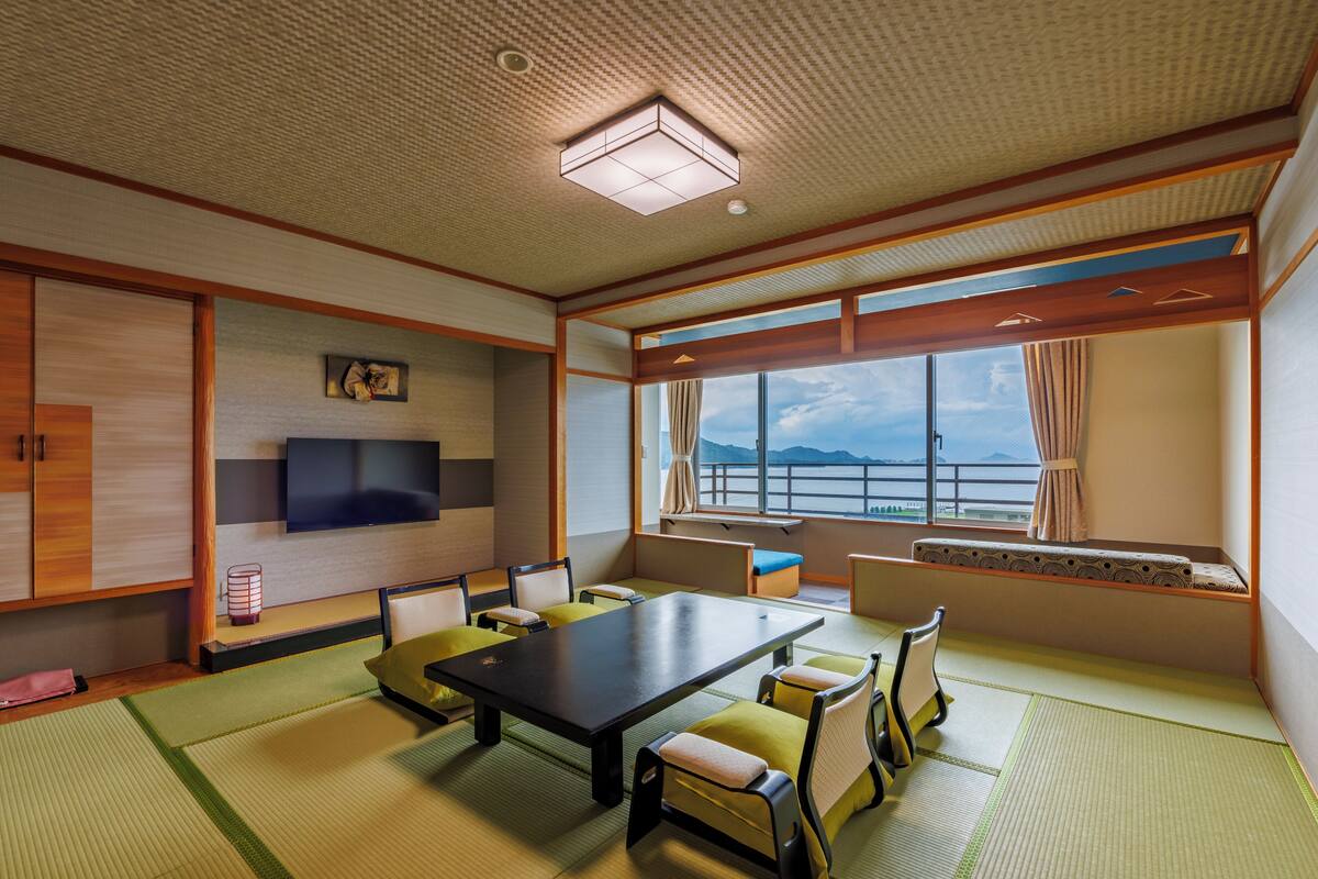 A traditional Japanese-style room with tatami flooring, a low table, and seating.