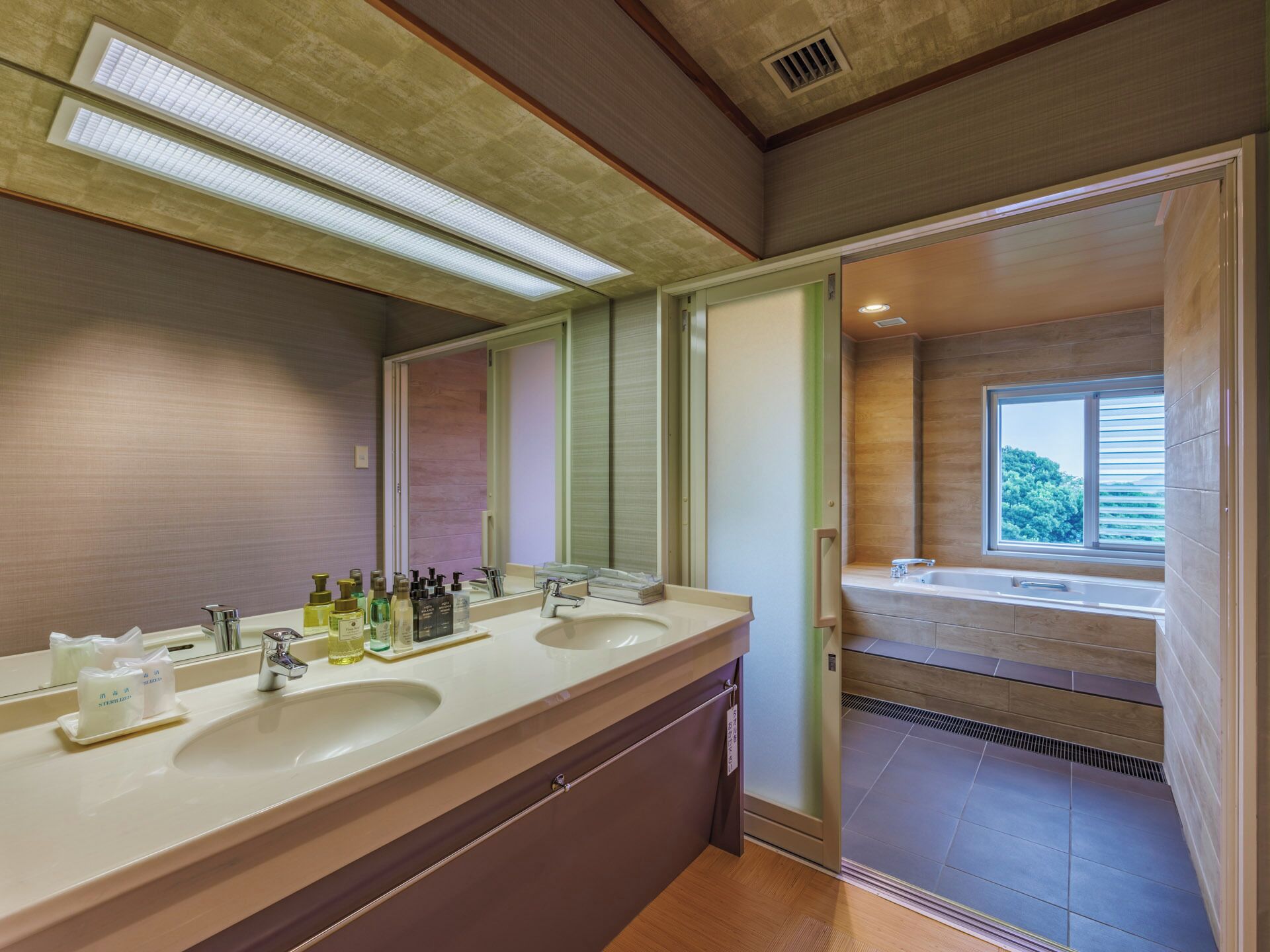 Un baño moderno con tocador doble, un espejo grande y vistas a la zona de ducha.