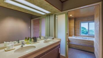 Un baño moderno con tocador doble, un espejo grande y vistas a la zona de ducha.