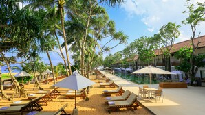 A beachside resort with sun loungers, umbrellas, and a pool area. - Pandanus Beach Resort & Spa (Induruwa)