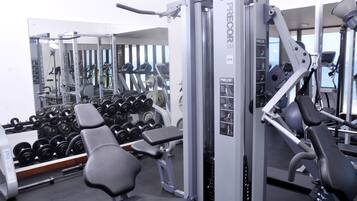 A gym with various exercise equipment, including dumbbells, benches, and weight machines.