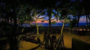 Ein Strand mit Palmen und Liegestühlen.