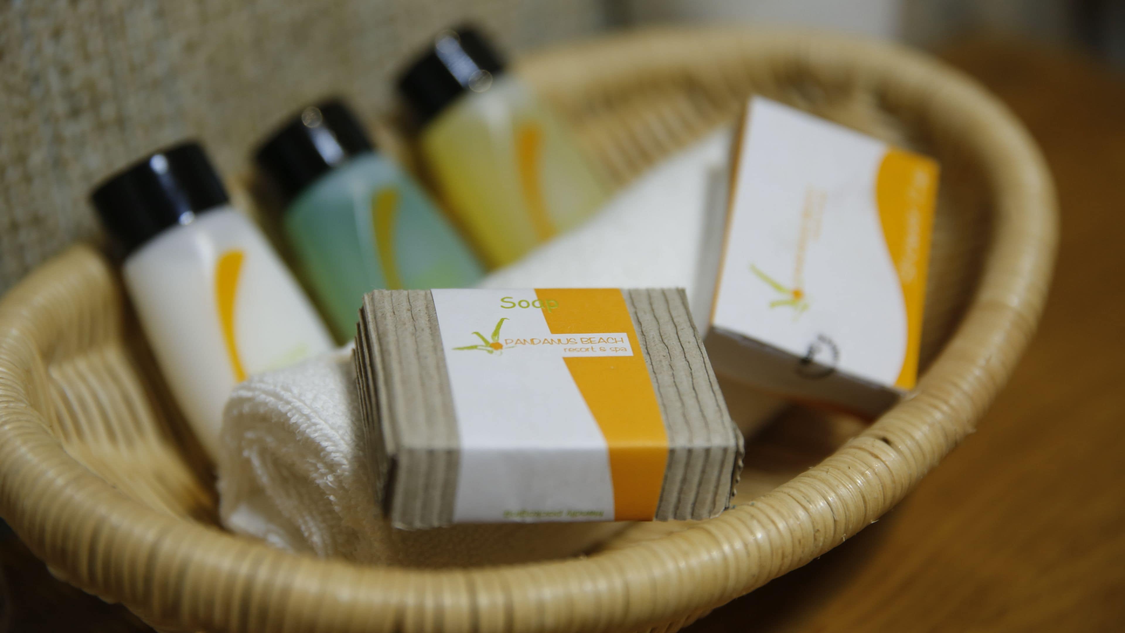 A basket containing several bottles of soap, some with labels indicating they are from a resort.