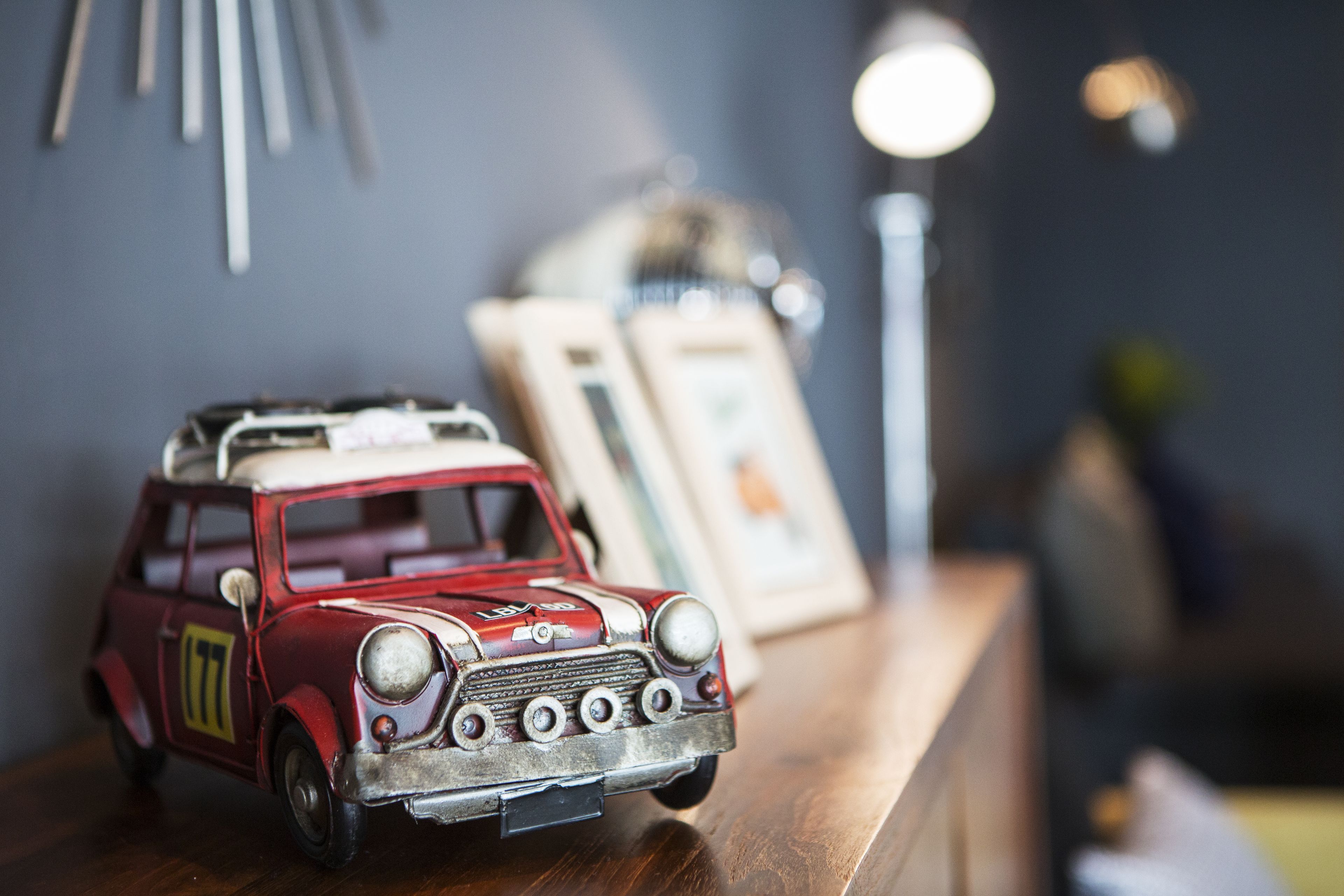 Une voiture jouet ancienne posée sur une surface en bois.
